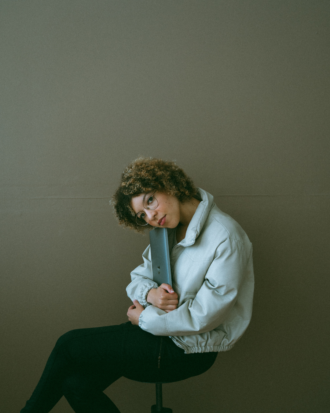 Woman sitting on chair leaning over her laption